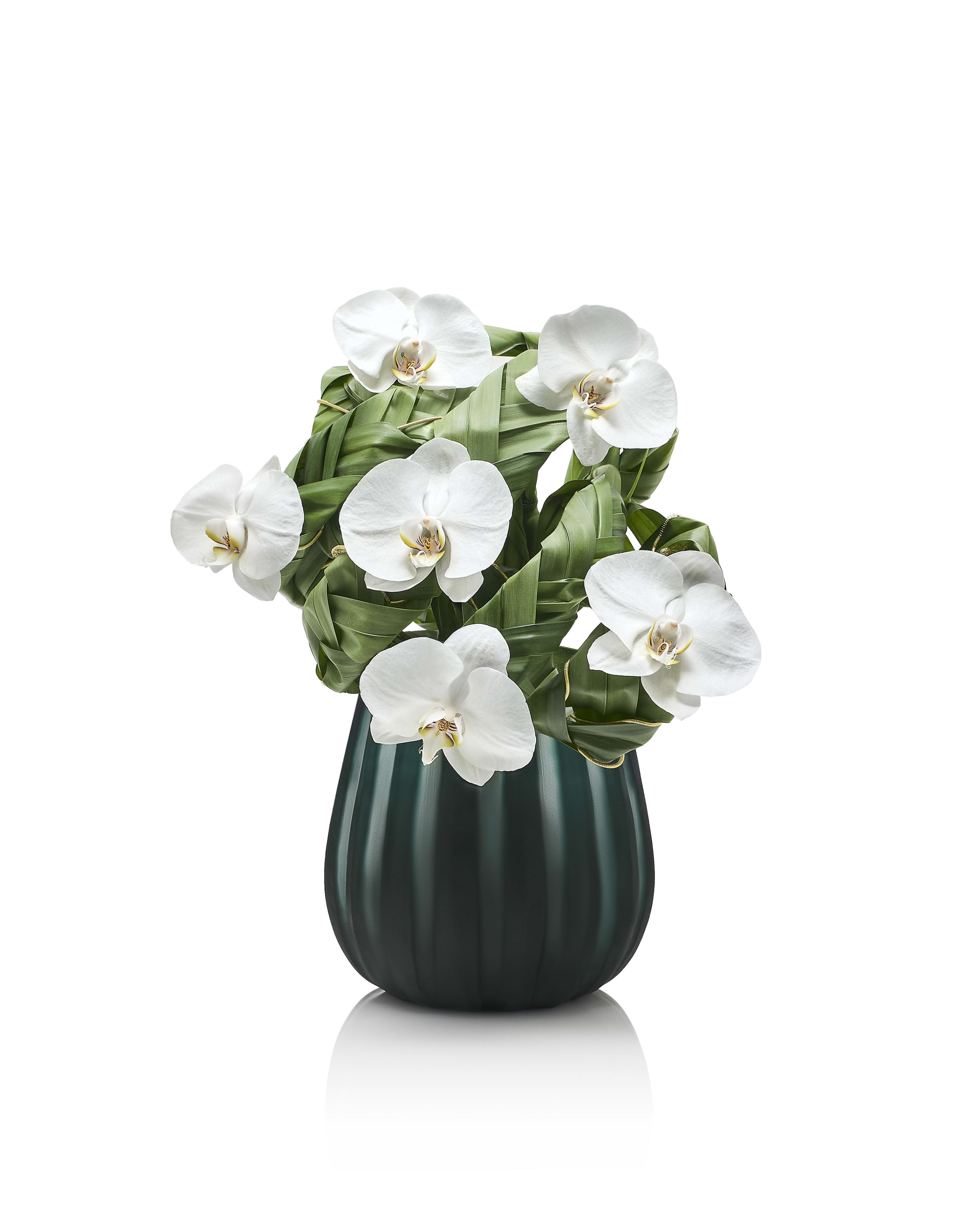 Phalaenopsis_orchids_and_philodendrum_leaves_on_green_glass_vase